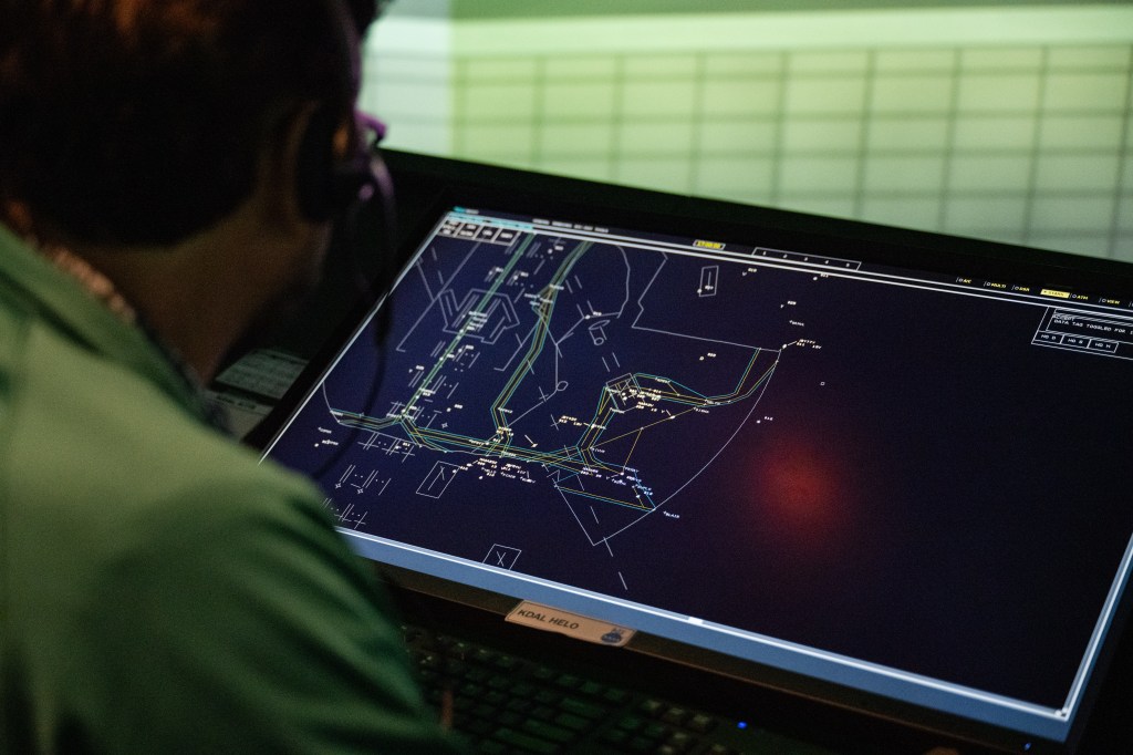 A tower controller monitors an airport surface display in FutureFlight Central. 