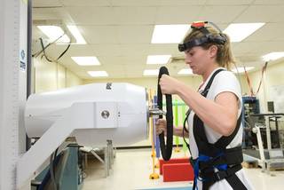 NASA test subject simulates opening a hatch door. 