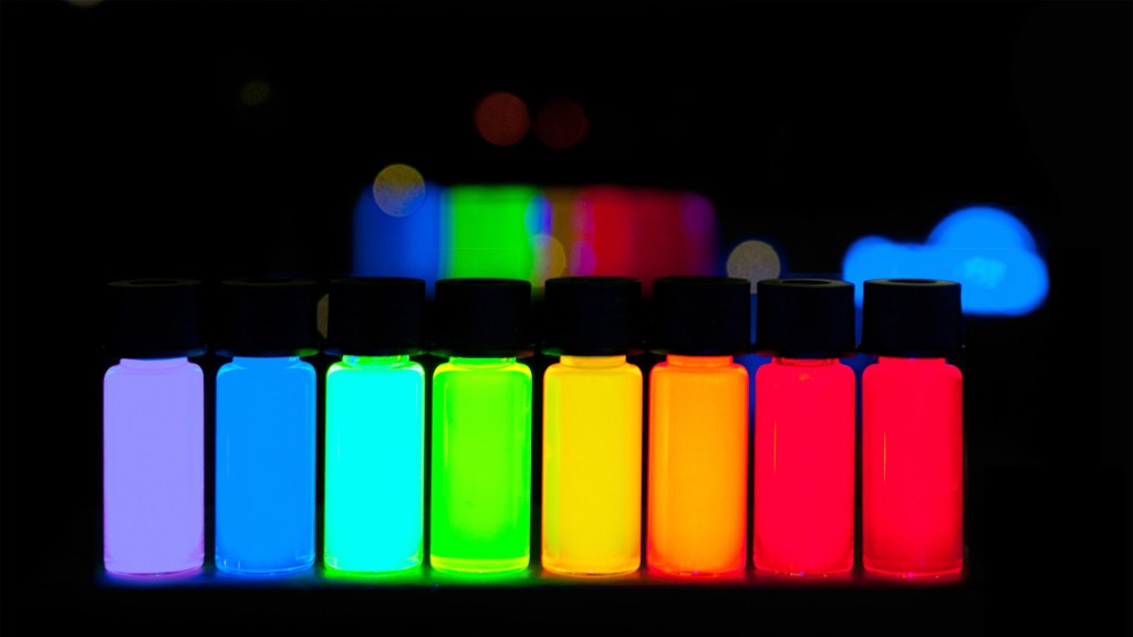 small vials containing quantum dots of varying sizes glow in different colors