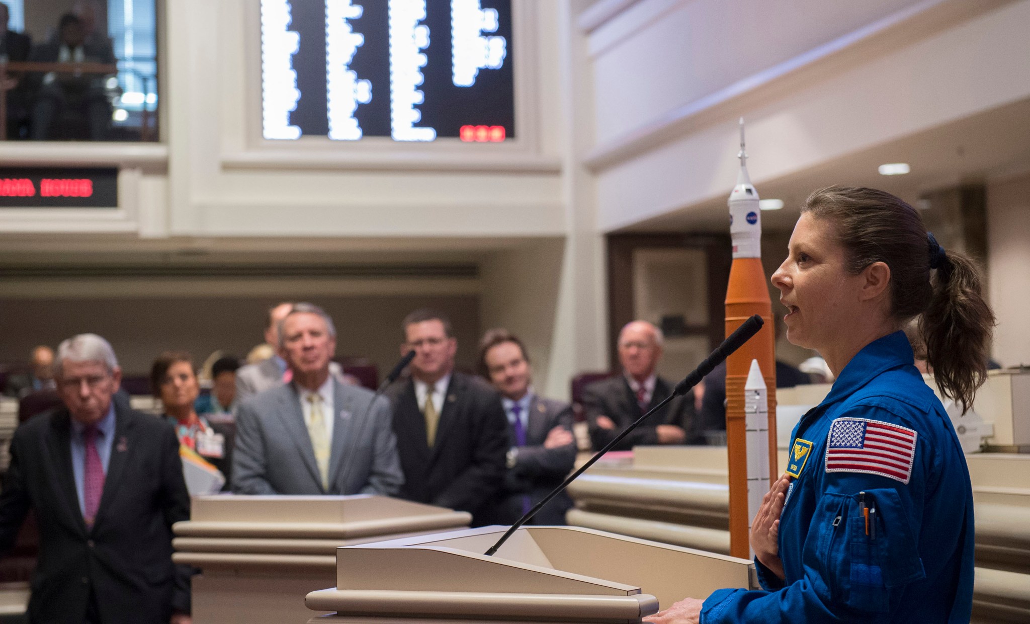 With a Space Launch System model beside her, NASA astronaut Tracy Dyson addresses members of the Alabama House of Representative