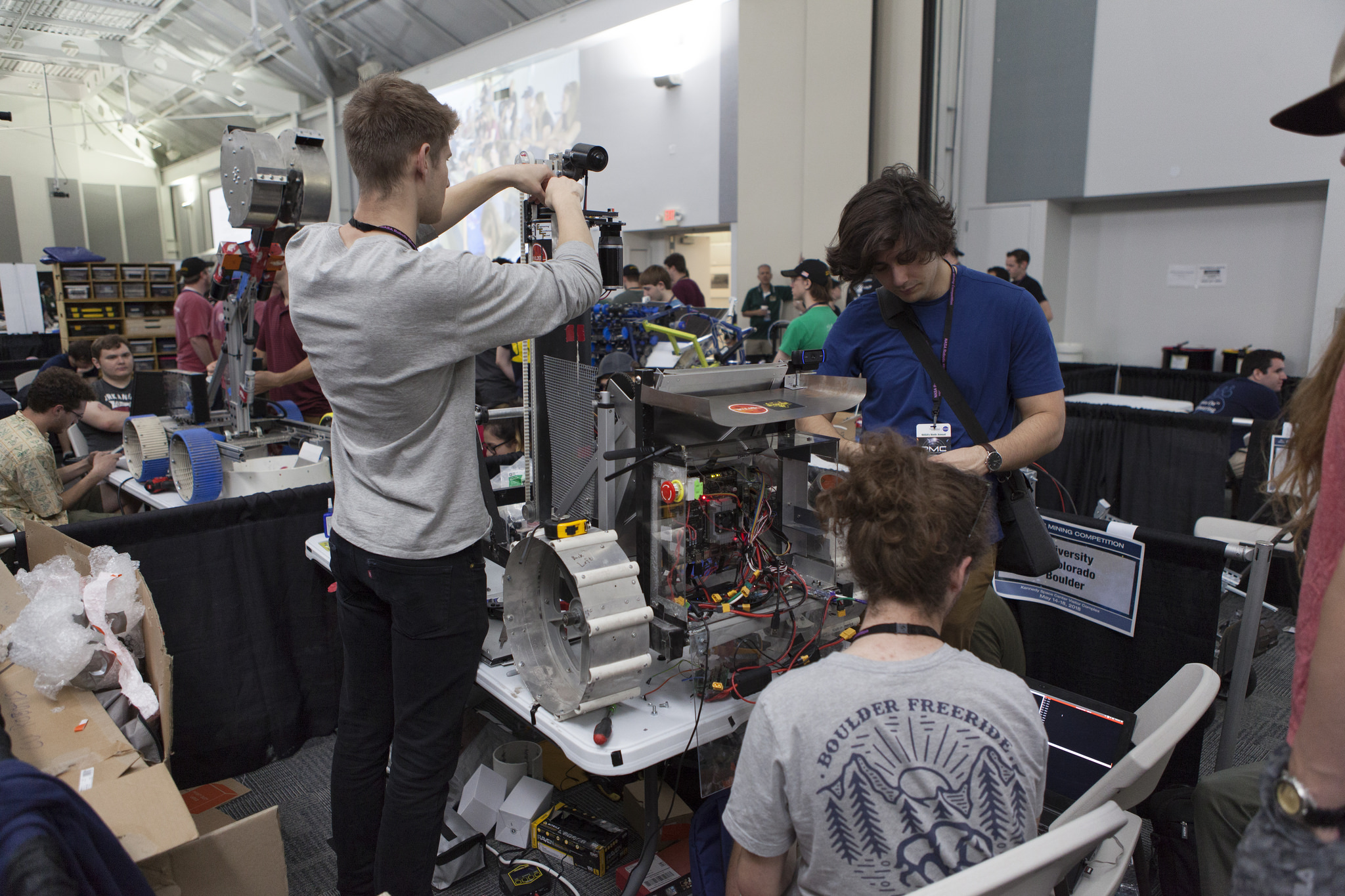 Team members from the University of Colorado Boulder work on their robot miner in the RobotPits.