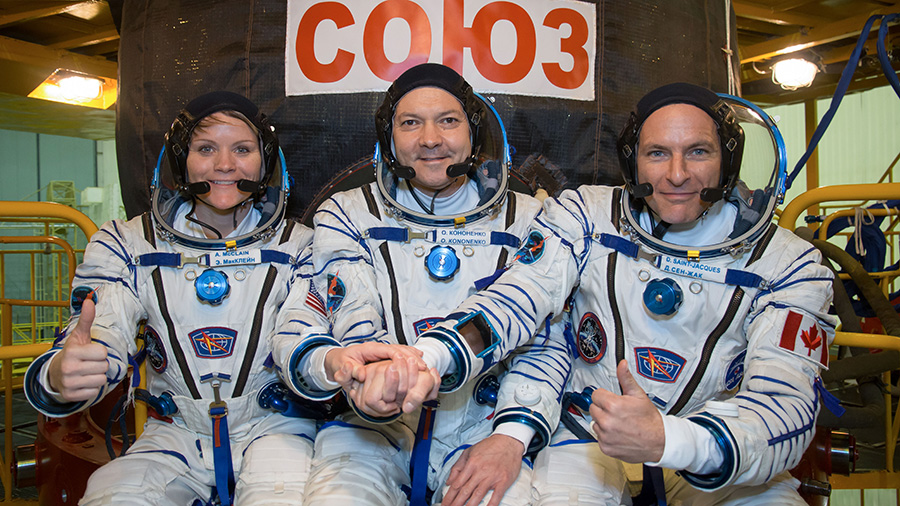 Expedition 58 crew members in front of their Soyuz MS-11 spacecraft