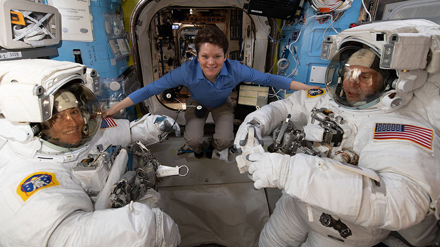 Astronaut Anne McClain assists fellow astronauts Christina Koch (left) and Nick Hague