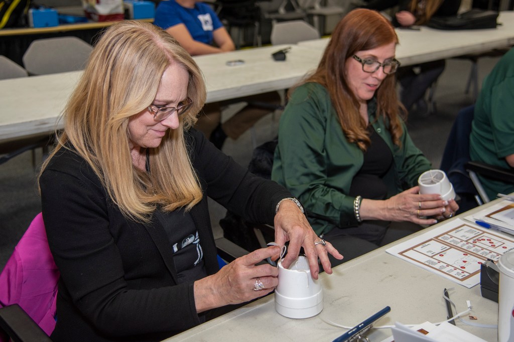 Teacher Kristen Deckner learns how to build a Remote Manipulator (Robotic) Arm.