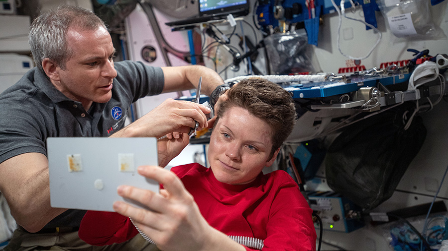 David Saint-Jacques of the Canadian Space Agency trims NASA astronaut Anne McClain’s hair