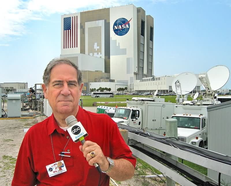 Vic Ratner, former radio broadcaster with ABC Radio, reporting in front of the Vehicle Assembly Building at Kennedy.