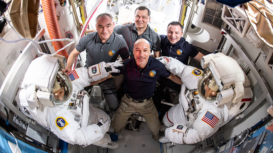 Spacewalkers Jessica Meir and Christina Koch pose with their Expedition 61 crewmates