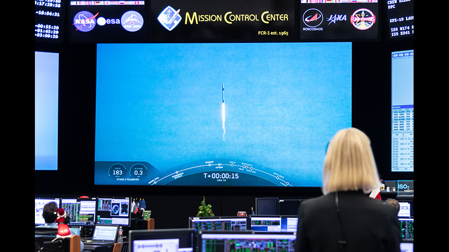 A mission controller in Houston watches the SpaceX Dragon resupply ship blast off