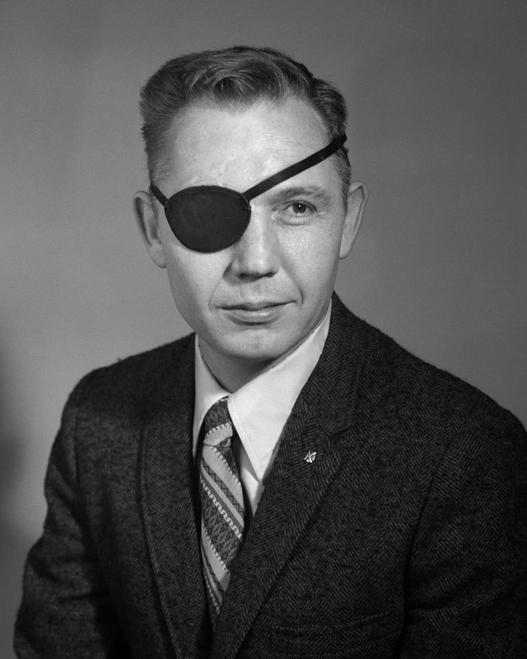 Black and white photo of man with an eyepatch.