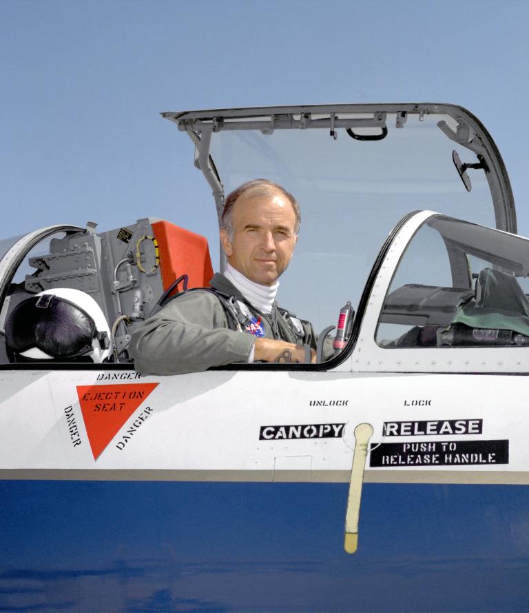 Man in aircraft, smiling.