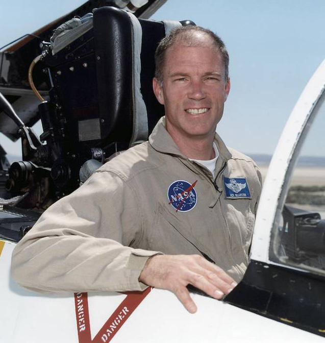 Man sitting in cockpit, smiling.