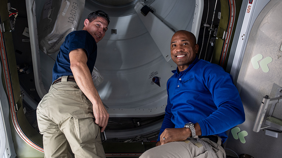 NASA astronauts (from left) Michael Hopkins and Victor Glover are pictured before opening the hatch to the newly docked SpaceX Cargo Dragon vehicle.