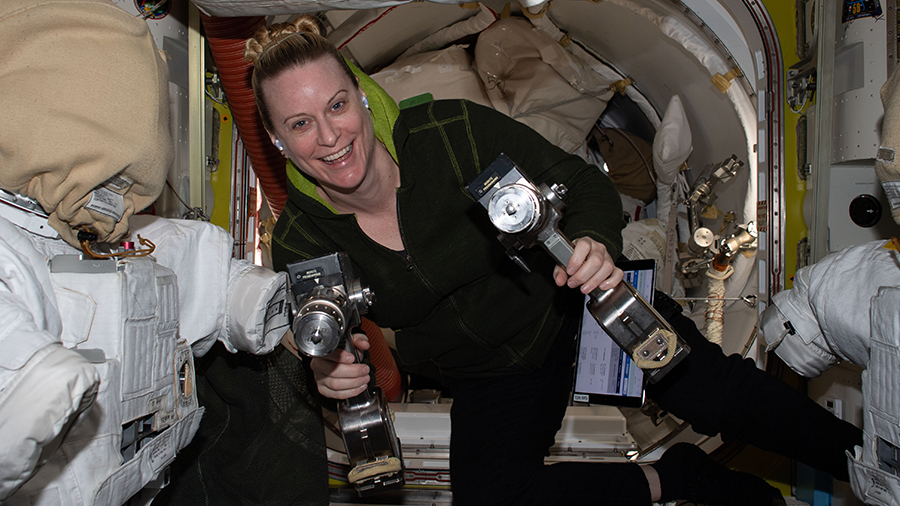 Expedition 64 Flight Engineer Kate Rubins is pictured inside the U.S. Quest airlock carrying a pair of pistol grip tools used for maintenance work during spacewalks.