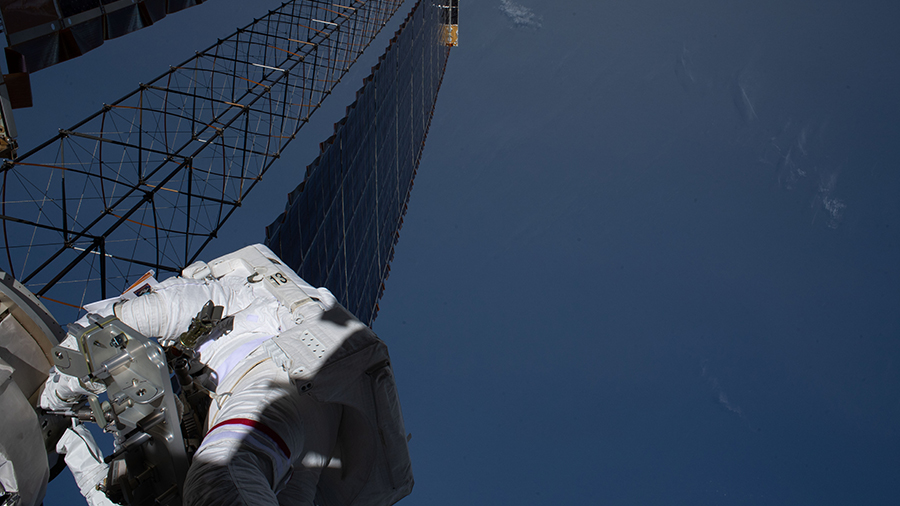 NASA astronaut Kate Rubins (lower left) is pictured during a spacewalk on Feb. 28, 2021, to install solar array modification kits on the space station.