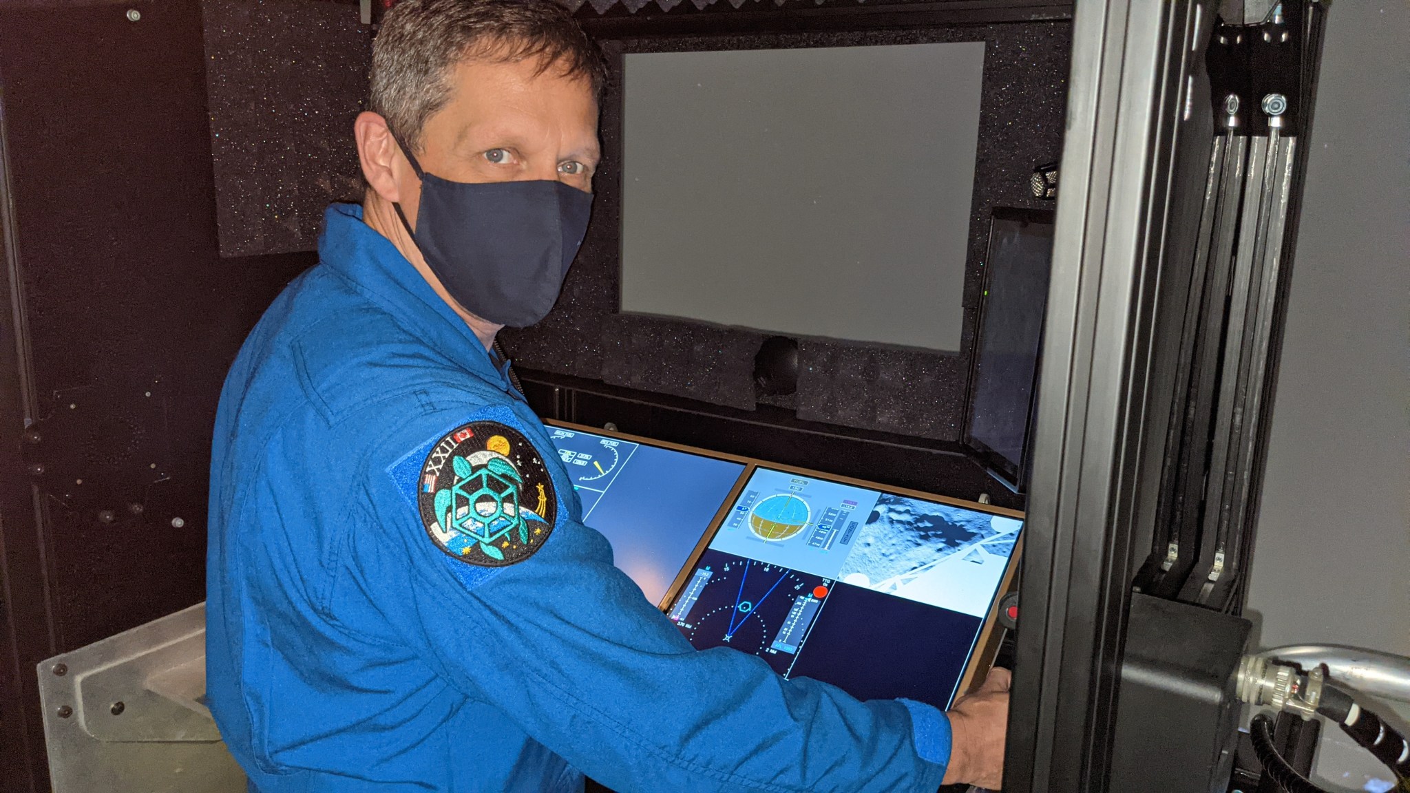 Astronaut Robert Hines at the controls of the lunar landing simulator