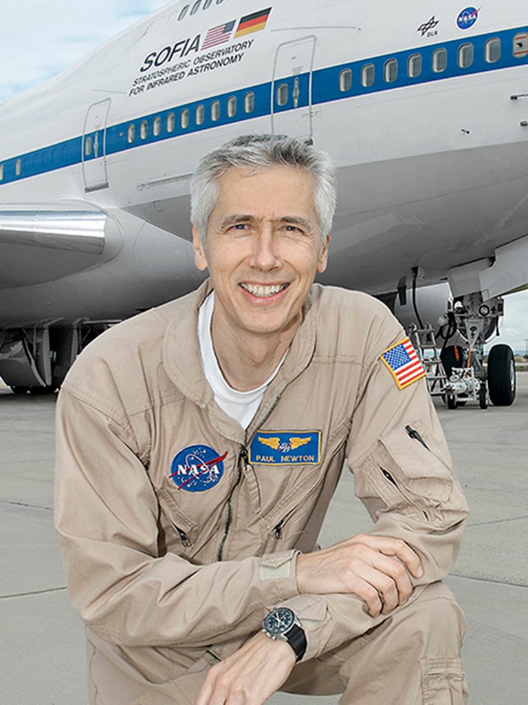 Man in flight suit posed in front of aircraft. 