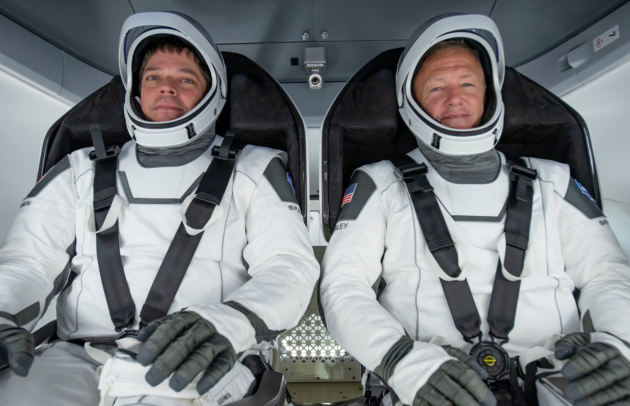 Bob Behnken, left, and Doug Hurley photographed inside the Crew Dragon spacecraft, wearing their SpaceX spacesuits.