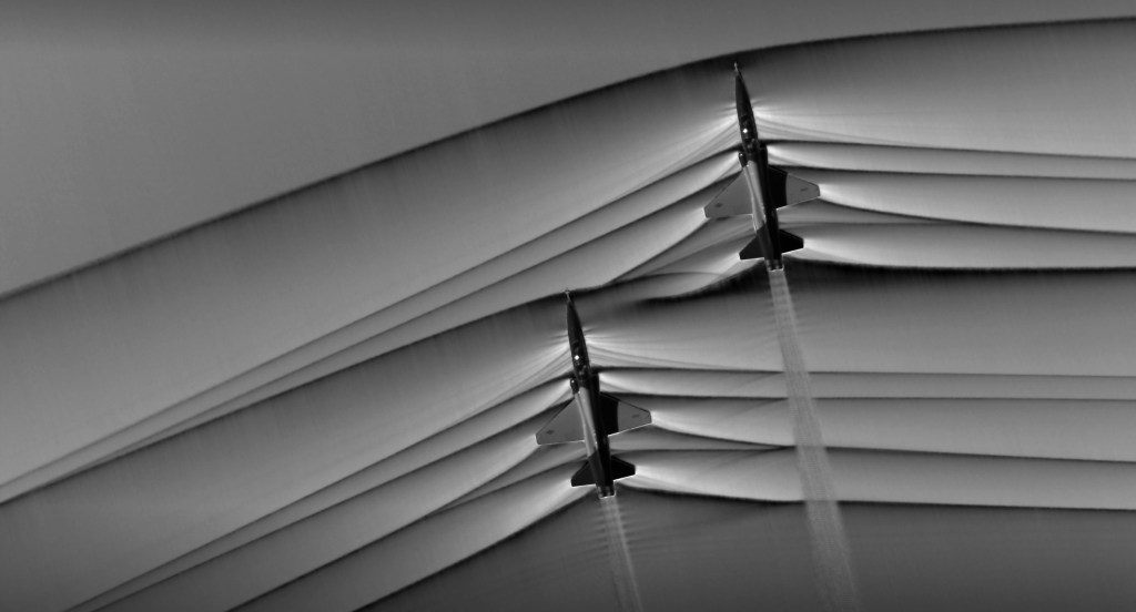 Schlieren photography image of two T-38 aircraft creating shockwaves.