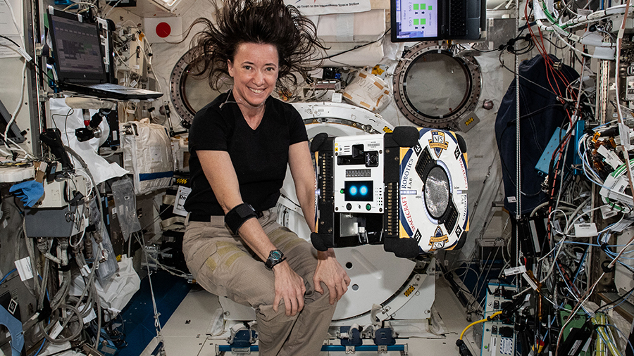 NASA astronaut Megan McArthur poses with an AstroBee robotic free-flying assistant inside the space station's Kibo laboratory module.