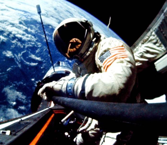 During the first standup spacewalk, astronaut Edwin E. “Buzz” Aldrin installs a temporary handrail to the Agena while standing in the hatch of the Gemini XII spacecraft.
