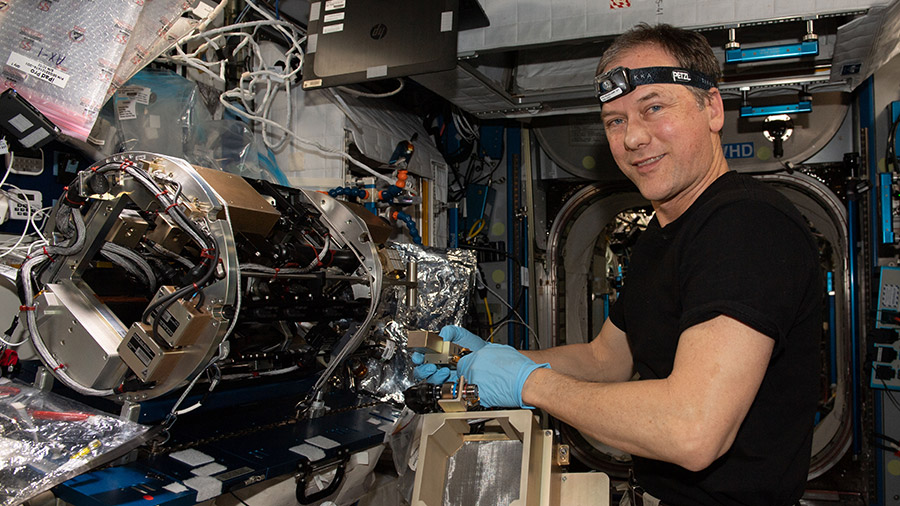 Expedition 67 Commander Thomas Marshburn configures hardware for material flammability and fire safety experiment.