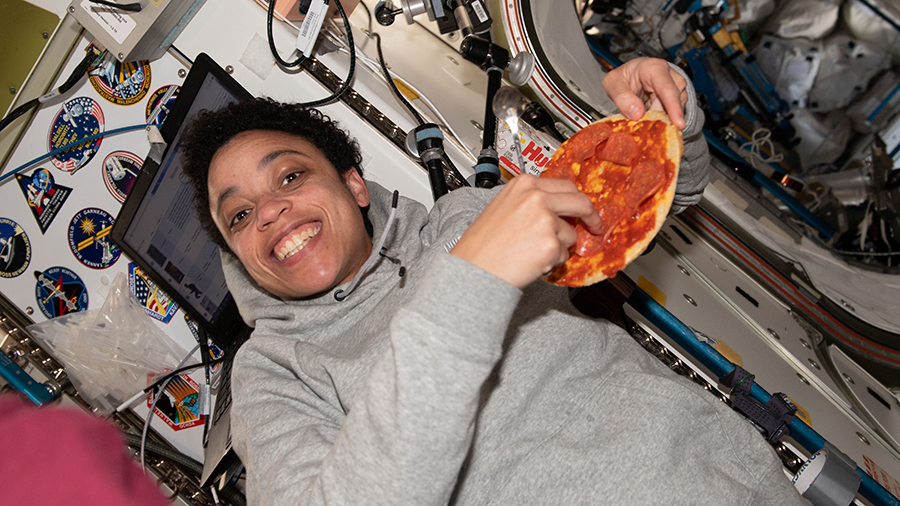 Astronaut Jessica Watkins enjoys a personal size pizza during dinner time aboard the space station.