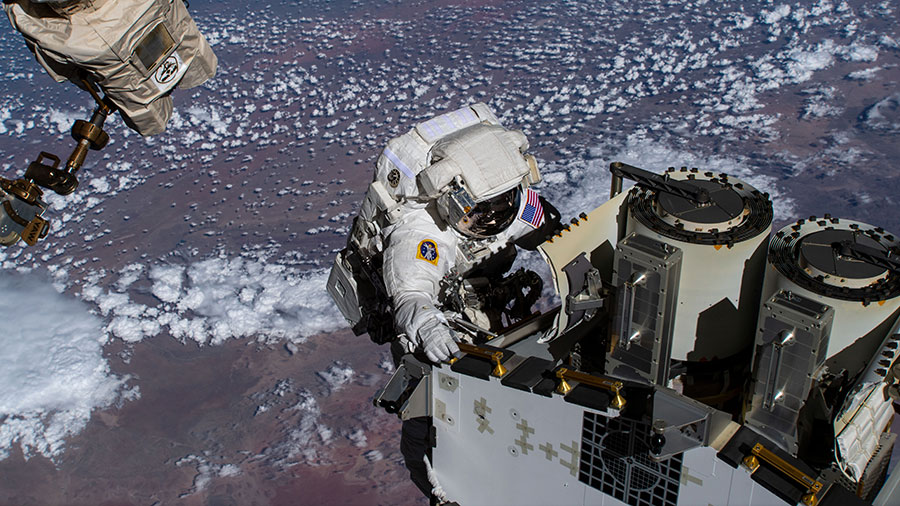 NASA spacewalker Josh Cassada prepares a roll-out solar array for its deployment on the space station's Port-4 truss segment as the orbiting lab flew above the Atlantic Ocean.