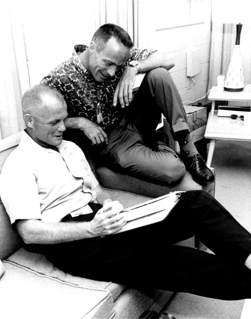 In the crew quarters of Hangar S at Cape Canaveral Air Force Station, astronaut John Glenn (left) makes last minute preparations with astronaut Scott Carpenter prior to the flight of MA-7.