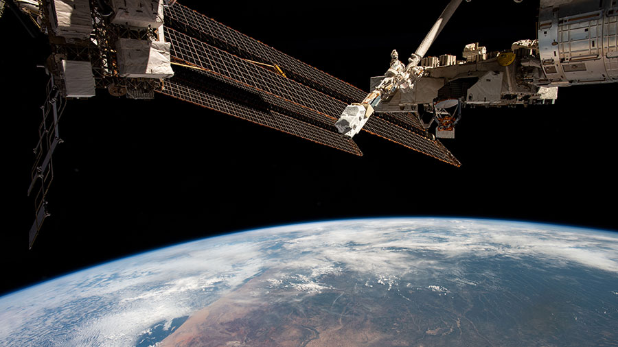 The space station's solar arrays and a small satellite orbital deployer are pictured as the orbiting lab soared above the African nation of Namibia.