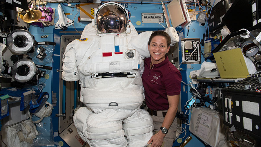 Astronaut Nicole Mann poses with an Extravehicular Mobility Unit (EMU), also known as a spacesuit, aboard the space station.