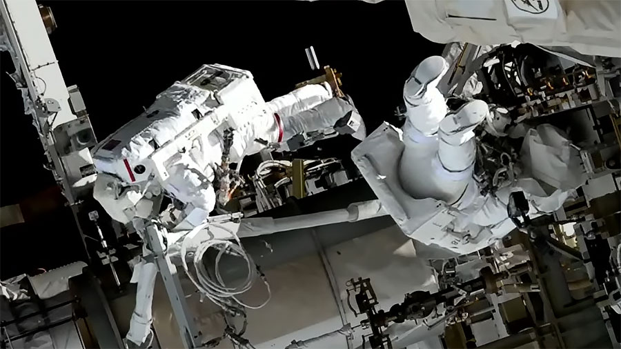 Spacewalkers (from left) Koichi Wakata and Nicole Mann are pictured installing hardware on the space station preparing the orbiting lab for its next roll-out solar array. Credit: NASA TV