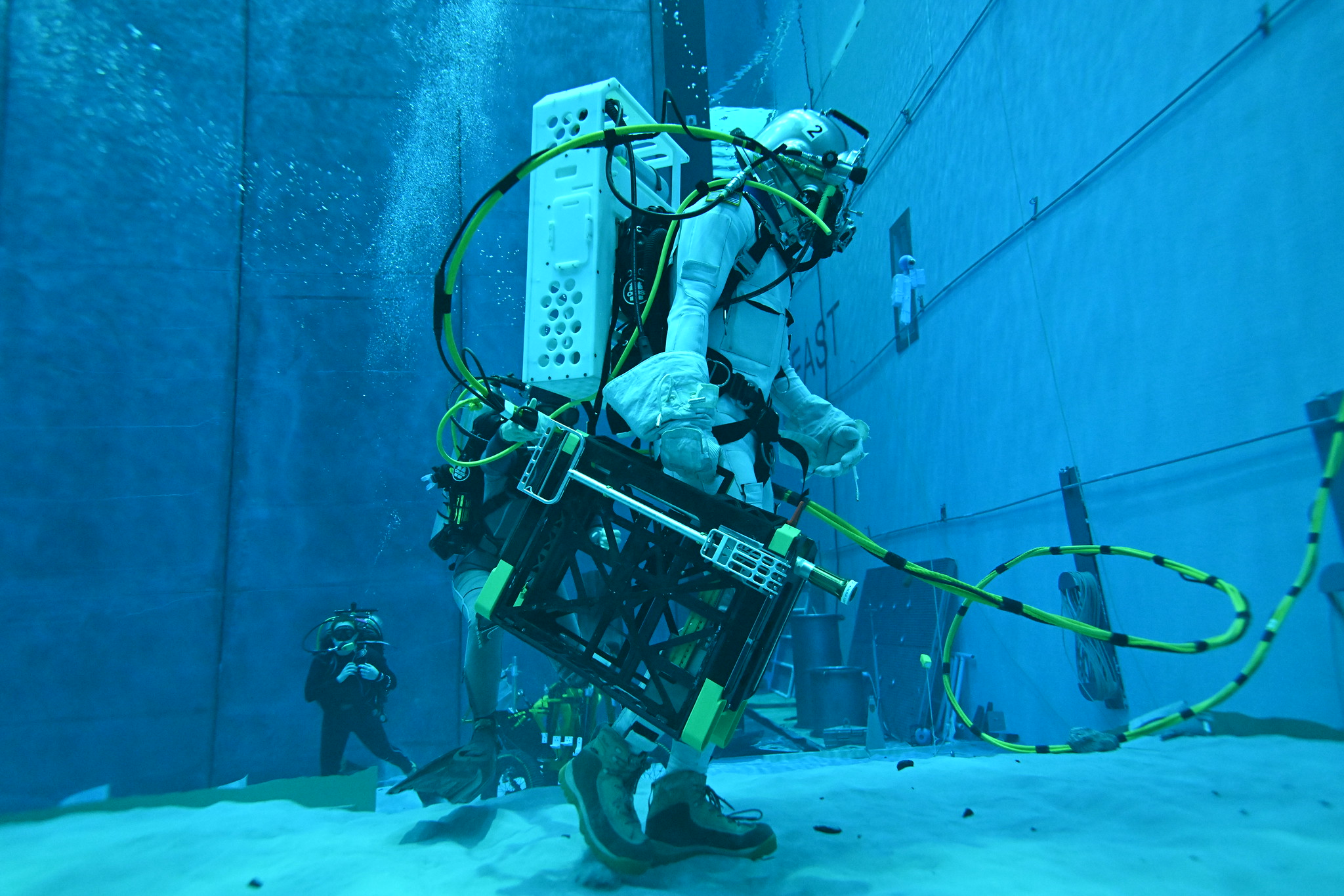 Diver tests a tool underwater in the Neutral Buoyancy Lab