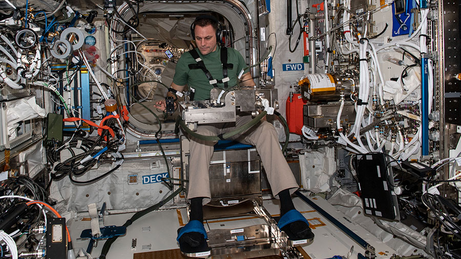 Astronaut Josh Cassada is seated in a specialized chair for an experiment that investigates how astronauts grip and move their arms when manipulating objects in microgravity.