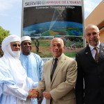 4 men shake hands in front of a SERVIR sign.