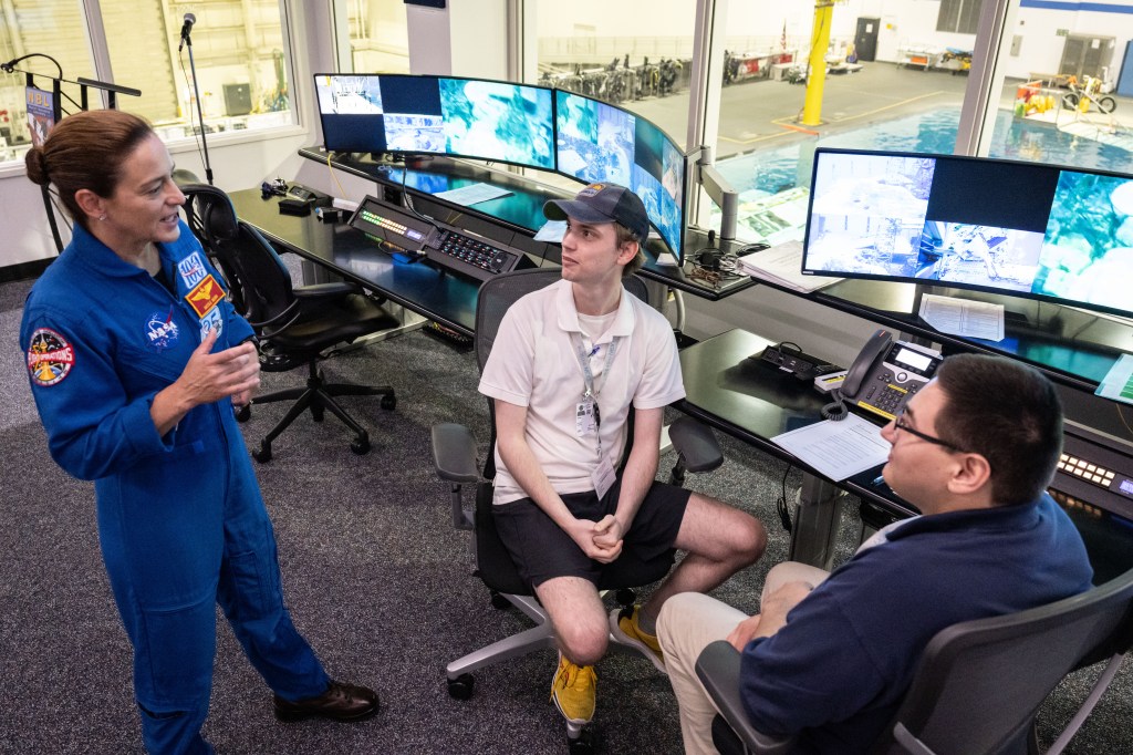 Astronaut Nicole Mann speaks to two students
