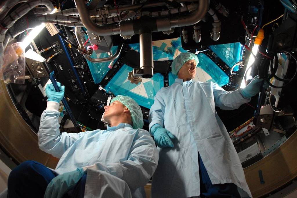 In the Space Station Processing Facility at NASA's Kennedy Space Center in Florida, astronauts Terry Virts, left, and Charles Hobaugh familiarize themselves with the robotic workstation inside the International Space Station's Cupola module.