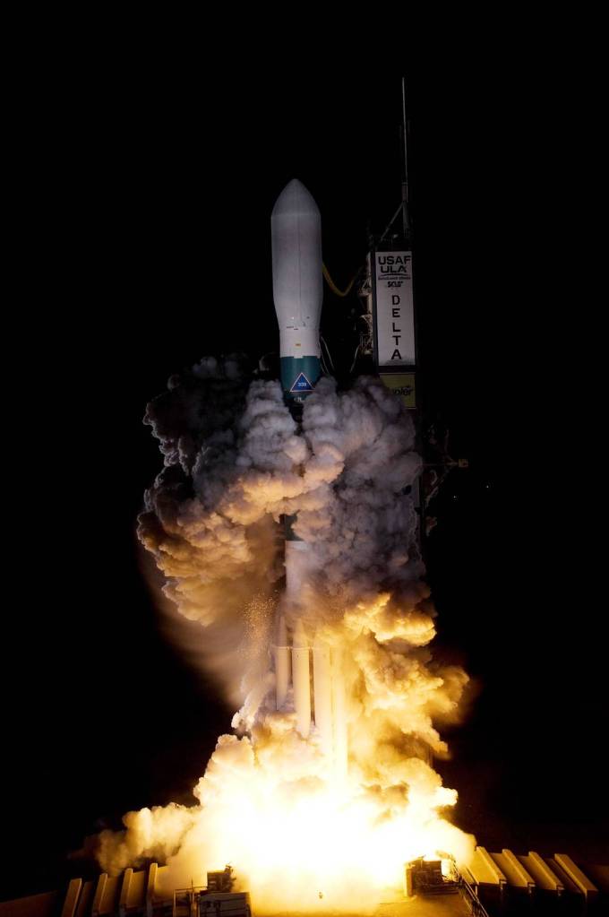 A Delta II rocket carrying NASA's Kepler spacecraft rises through the exhaust cloud created by the firing of the rocket's engines. 