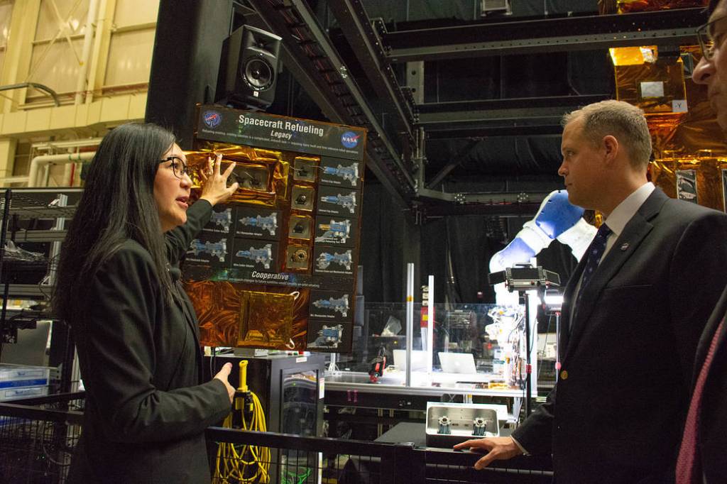 NASA Administrator speaks with Goddard scientist near robotic equipment