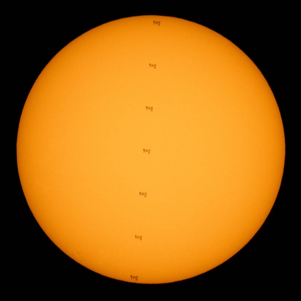 This composite image made from seven frames shows the International Space Station, with a crew of seven onboard, in silhouette as it transits the Sun

