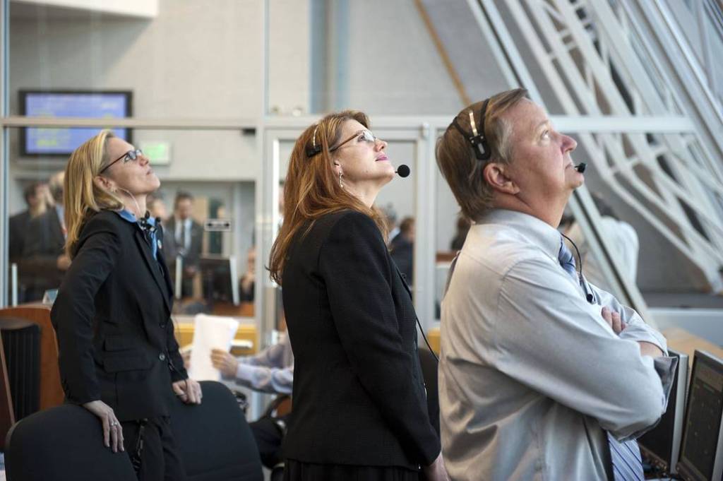 Mission managers for STS-133 watch from the Launch Control Center's windows as space shuttle Discovery lifts off the final time.