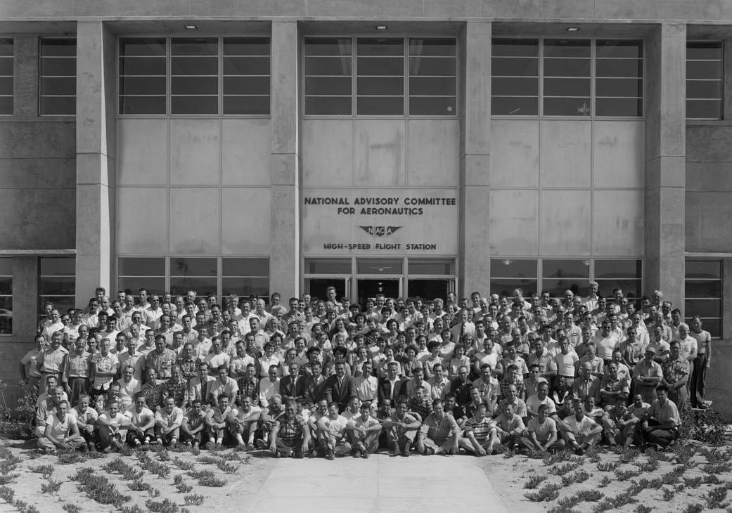 Personnel of the NACA High-Speed Flight Station gathered for a group photo in front of the station's new headquarters, Bldg. 480
