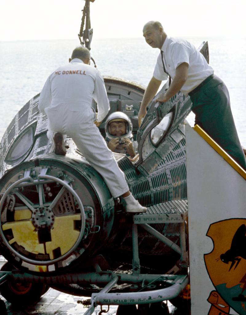 Gemini VI command pilot Wally Schirra climbs from his spacecraft after splashdown  