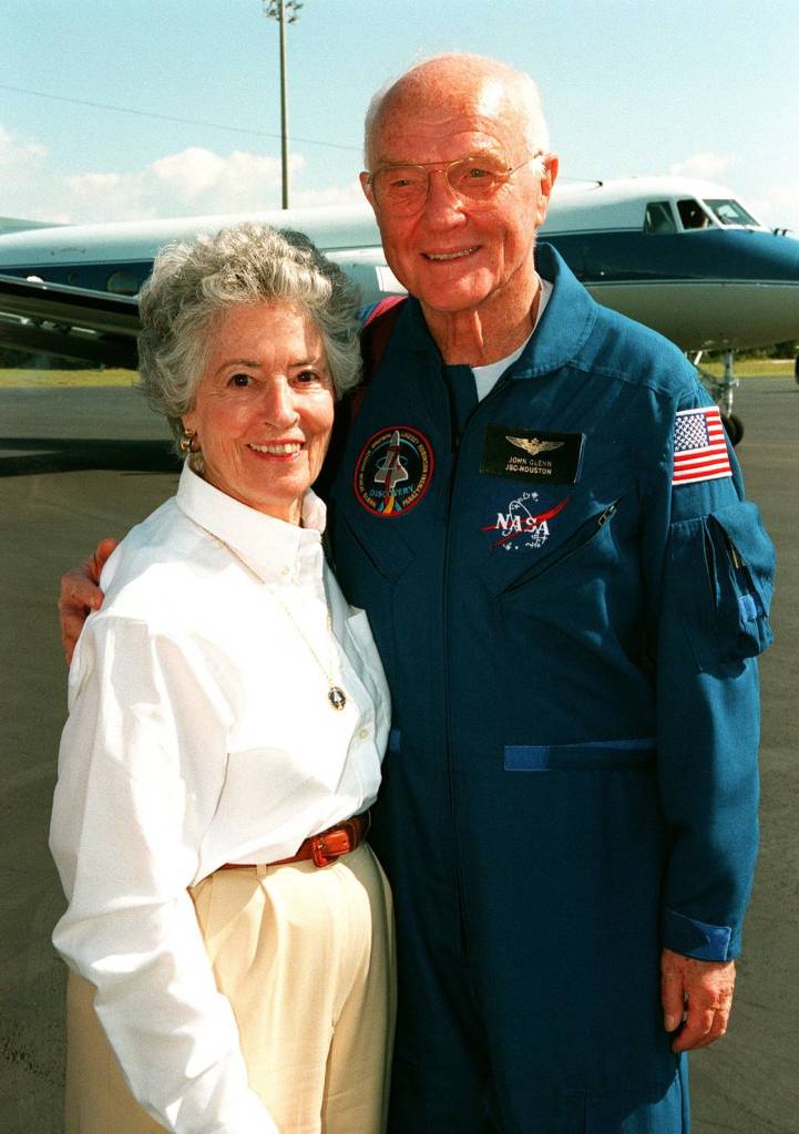 John Glenn in blue flight suit poses for photo with his wife Annie