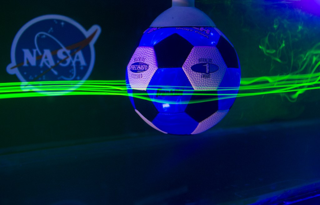 soccer ball in a water chamber with lasers around soccer ball