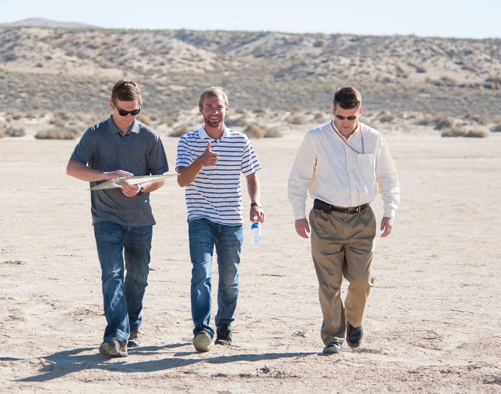 Emerson Baker, Alexander Flock and Ryan Dibley retrieve the Prandtl-M after a successful test flight.