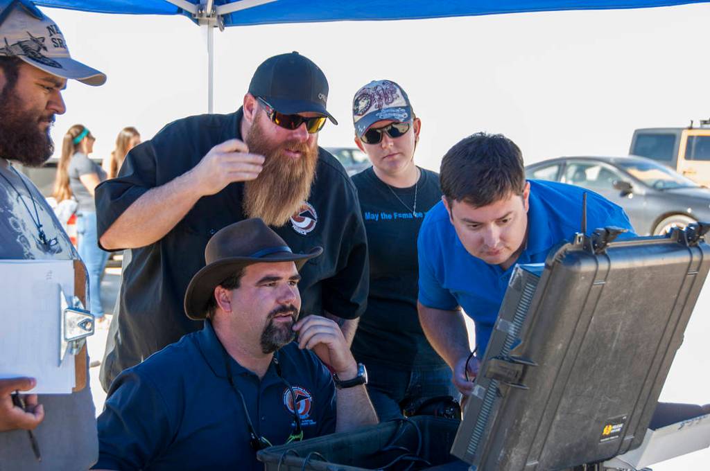 Jonathan Adams, from left, John Bodylski, Justin Hall, Caitlin Kennedy and Dave Berger watch a computer screen.