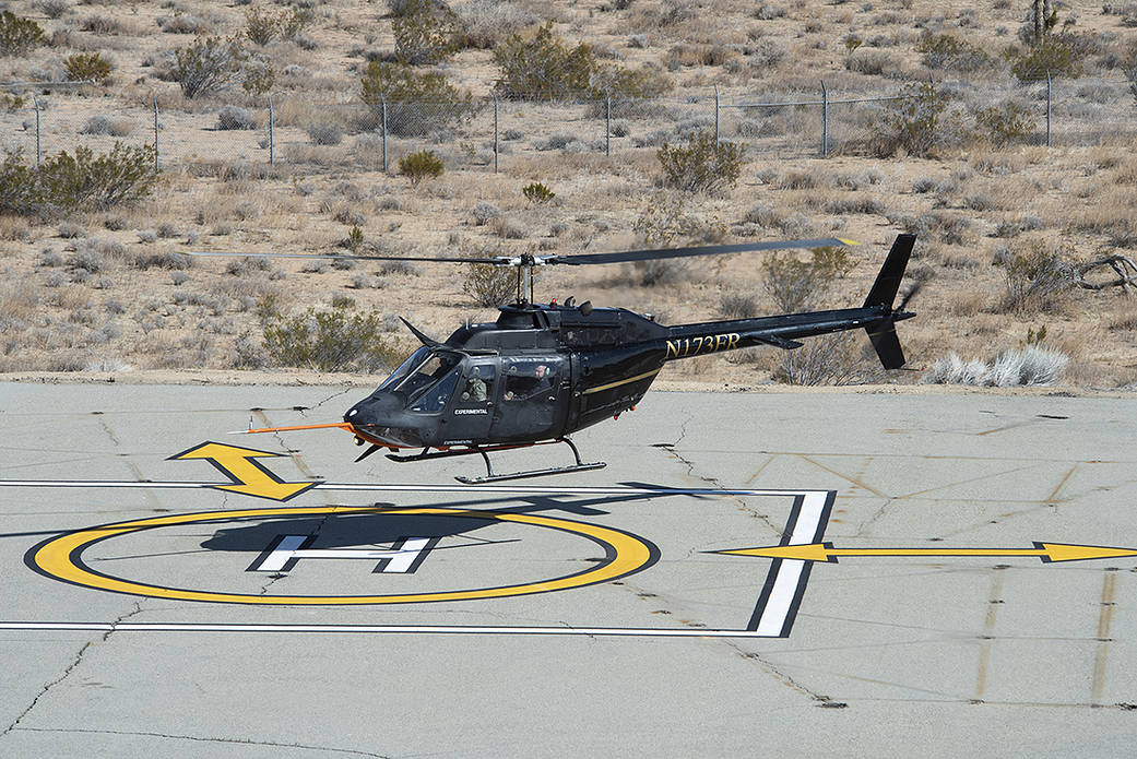 Flight Research Inc.’s Bell OH-58C Kiowa helicopter hovers over a helipad 