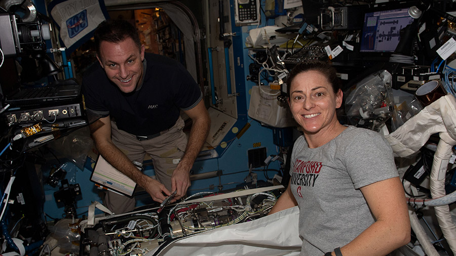 Expedition 68 Flight Engineers Josh Cassada and Nicole Mann, both from NASA, work on life support maintenance inside the Destiny laboratory module.