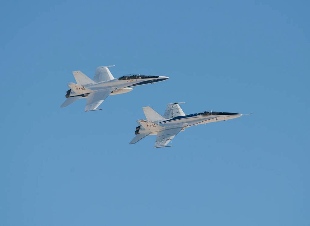 Two F/A-18 aircraft flying in tight formation.
