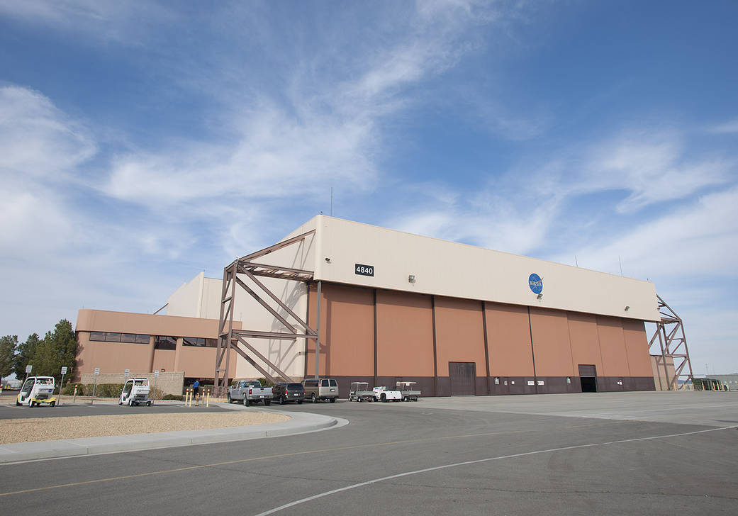 A large hanger with a split 225 X 50-foot door and metal staircases on both sides. To the right of the hangar is a smaller attached section of the structure for support staff.